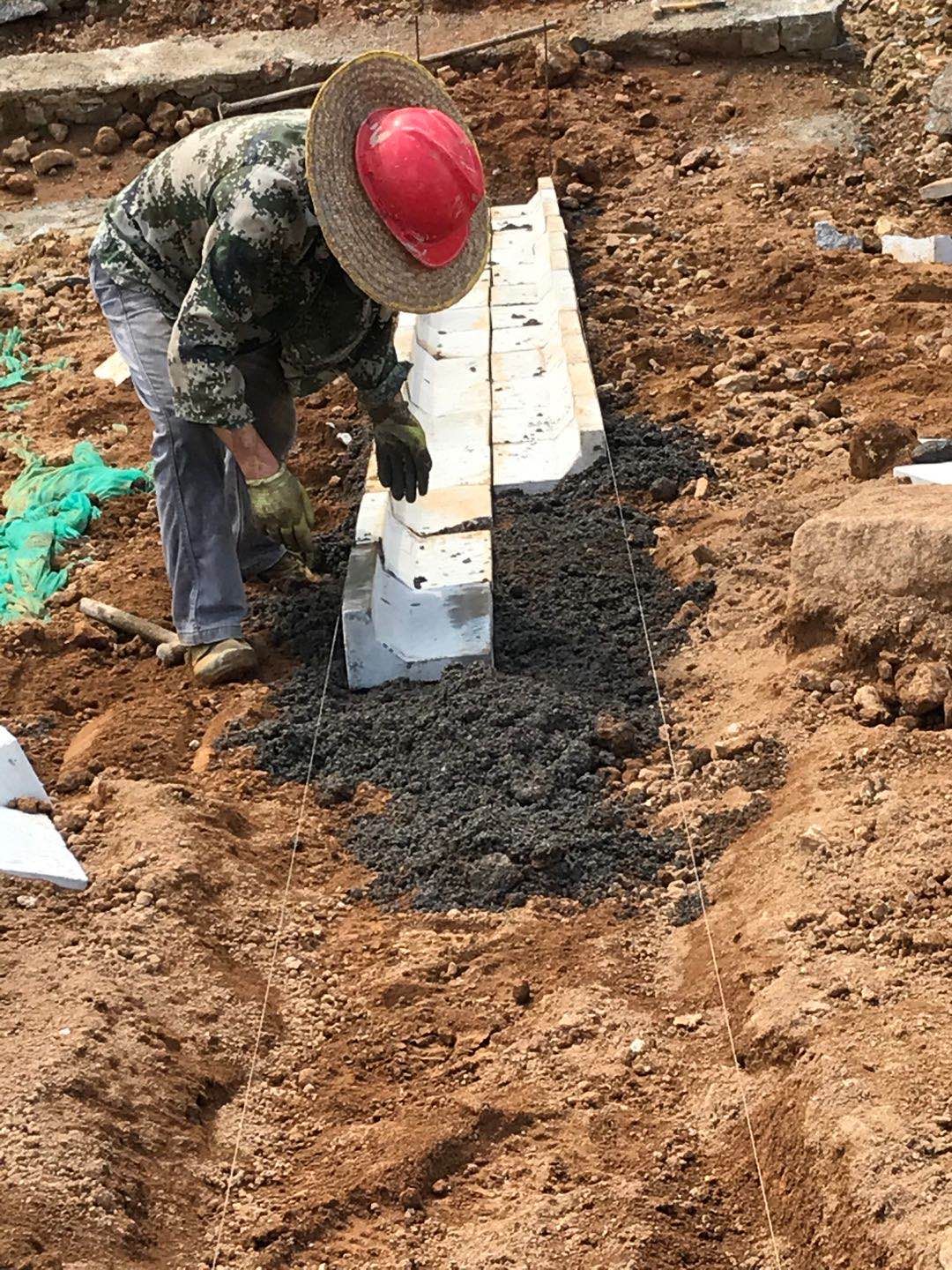 工作人员正在使用人字型骨架预制块搭建水泥骨架护坡